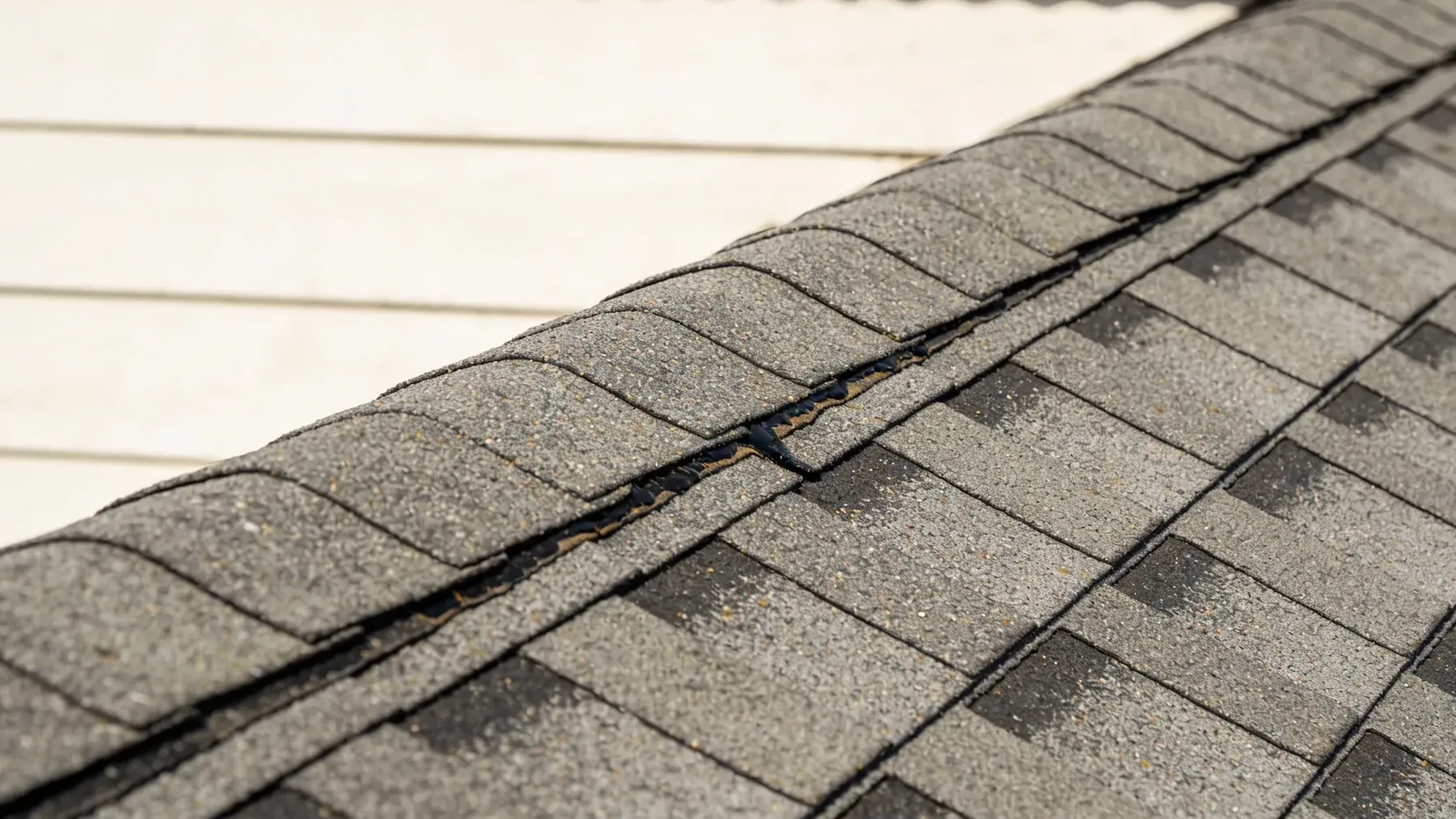 Close view of an asphalt shingle roof ridge.